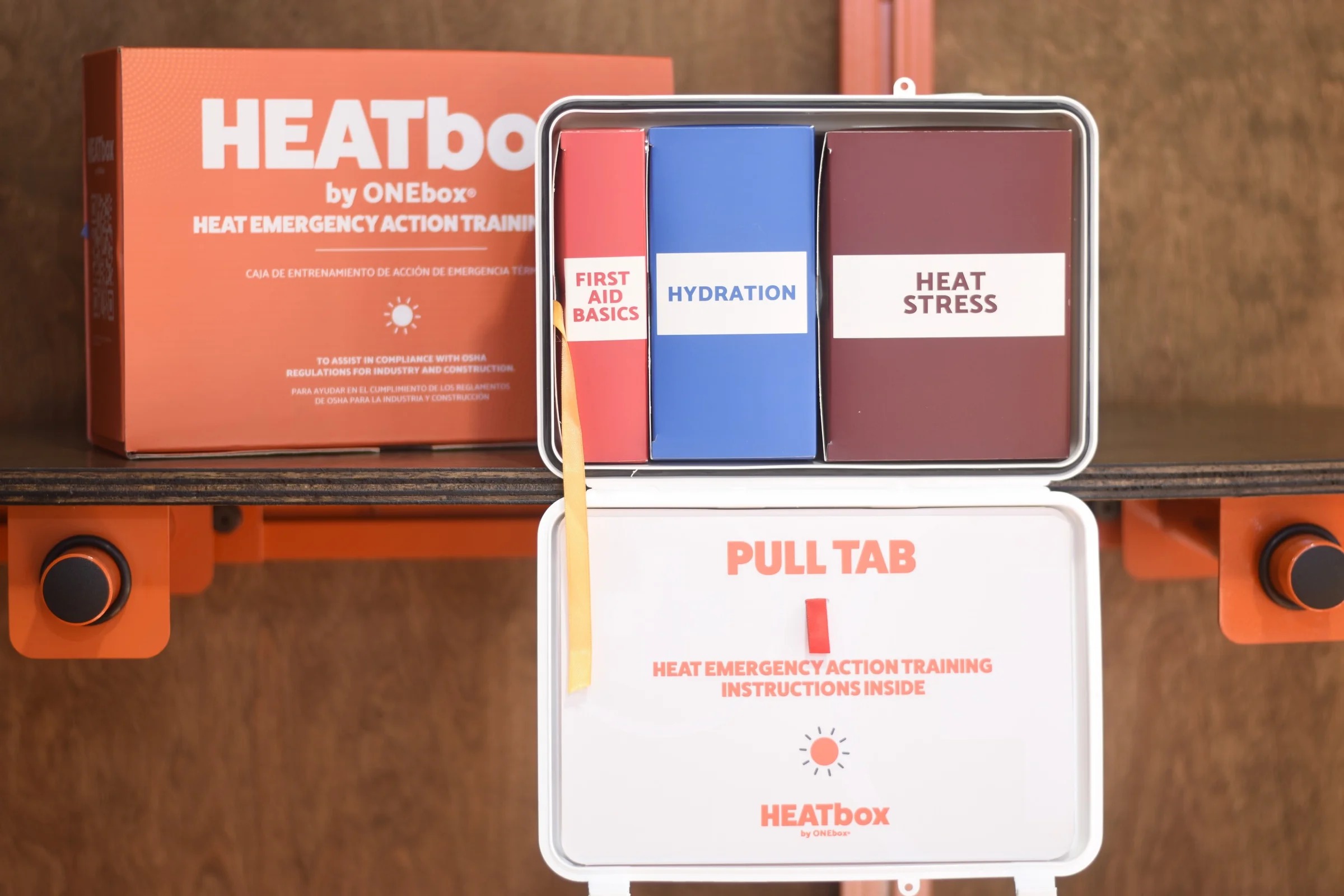 An open HEATbox on the wall with first aid basics, hydration packs, and heat stress tools.